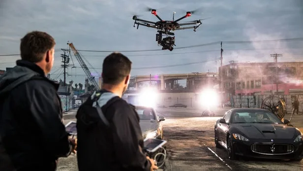 Drone filming a car commercial with a film crew