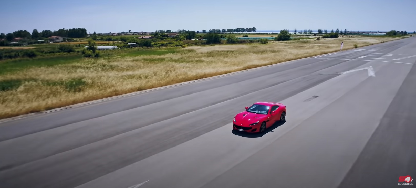 Auto sportiva rossa in pista ripresa dal drone